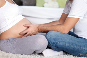 man touching stomach his pregnant woman